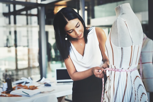 Tendré que despegar unos centímetros Fotografía de una joven diseñadora de moda exitosa que trabaja en su último diseño