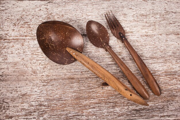 Tenedor y cuchara de madera sobre fondo de madera soplado