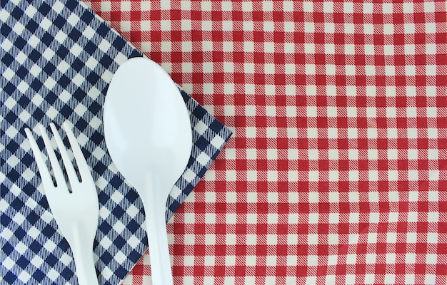 Tenedor y cuchara sobre mantel para servir comida de fondo