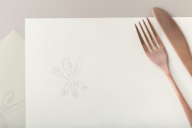 Foto tenedor y cuchillo de cobre sobre papel reciclado