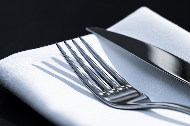 Tenedor y cuchillo con servilleta blanca sobre la mesa en un restaurante de lujo al aire libre menú de alta cocina para bodas ...