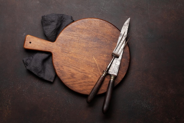 Tenedor y cuchillo vacíos de la tabla de cortar