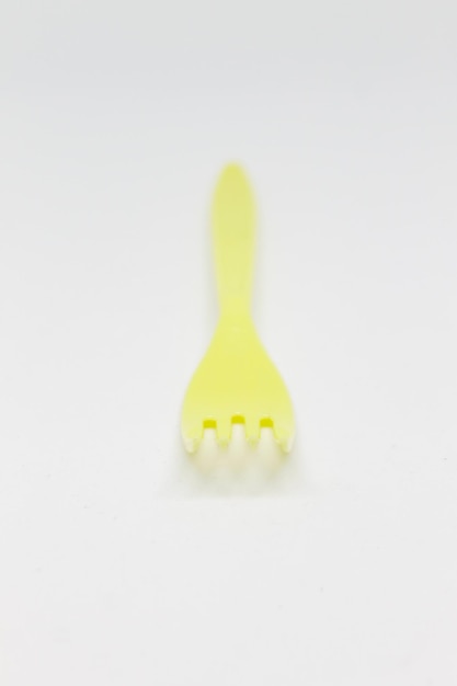 Un tenedor de plástico amarillo con la parte superior hecha por un tenedor.