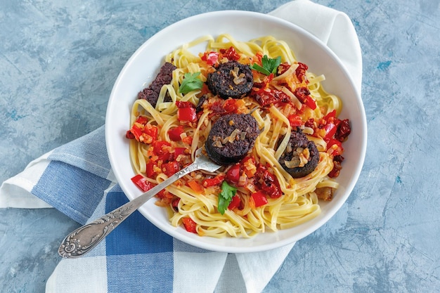 Tenedor en un plato con pasta italiana y morcillas