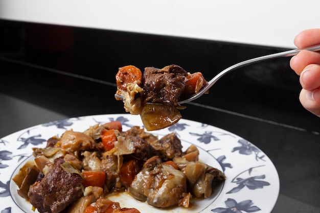 Foto tenedor con una porción de ragú de ternera con verduras