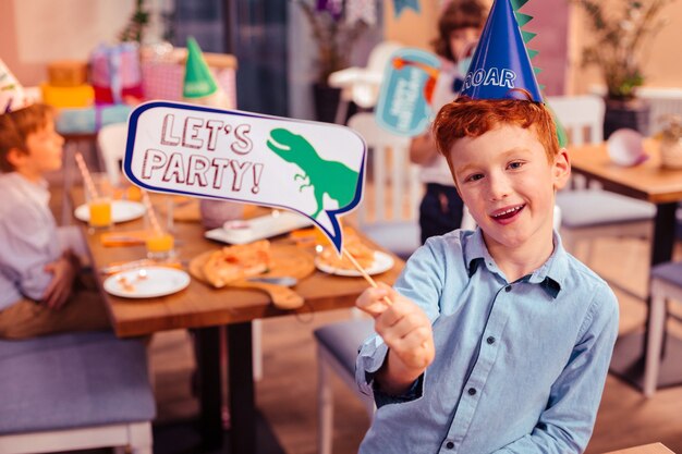 Tener fiesta. Adolescente encantado sintiendo felicidad mientras posa