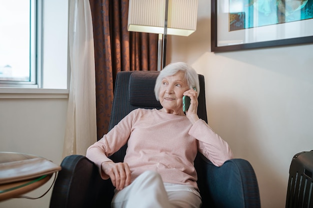 Tener una llamada. Dama elegante de pelo corto hablando por teléfono