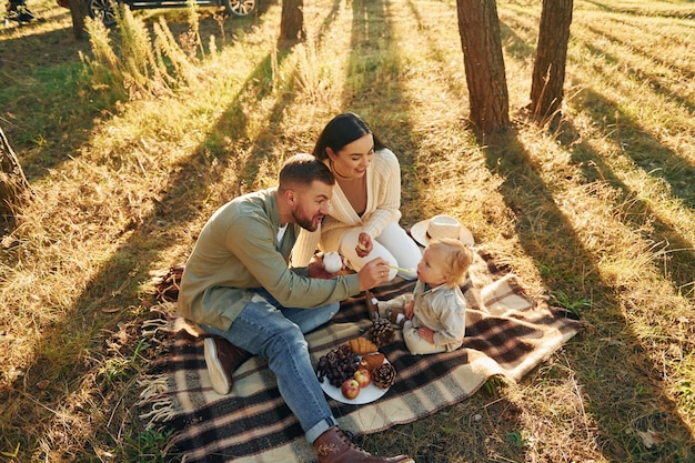 Foto tener picnik familia feliz de padre madre e hija pequeña está en el bosque