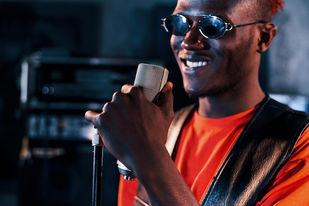 Tener práctica vocal Joven intérprete afroamericano ensayando en un estudio de grabación