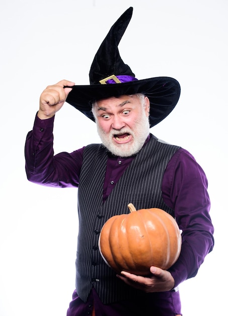 Tenga un mago de hombre maduro de Halloween espantosamente espeluznante con sombrero de bruja feliz halloween hombre barbudo listo para la fiesta de halloween mago malvado sostenga calabaza Stargazer en traje de fiesta Comida tradicional