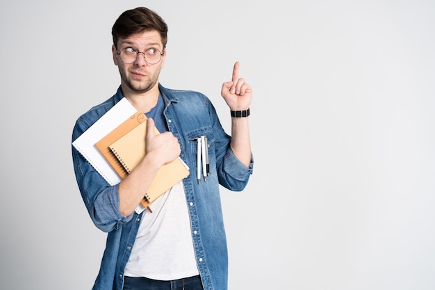 Tengo una idea brillante. Hombre alegre caucásico, levanta el dedo índice, tiene un plan intrigante aislado con espacio de copia Apuesto estudiante inteligente usa gafas redondas