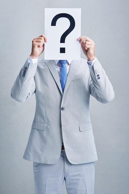 Tengo todas las respuestas a sus preguntas Foto de estudio de un hombre de negocios con un traje gris posando sobre un fondo gris