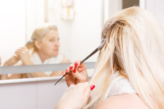 Teñido del cabello en el baño doméstico. Una sola mujer