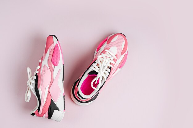 Tênis da moda feminina em um fundo rosa. Sapatos esportivos femininos. Conceito de fitness