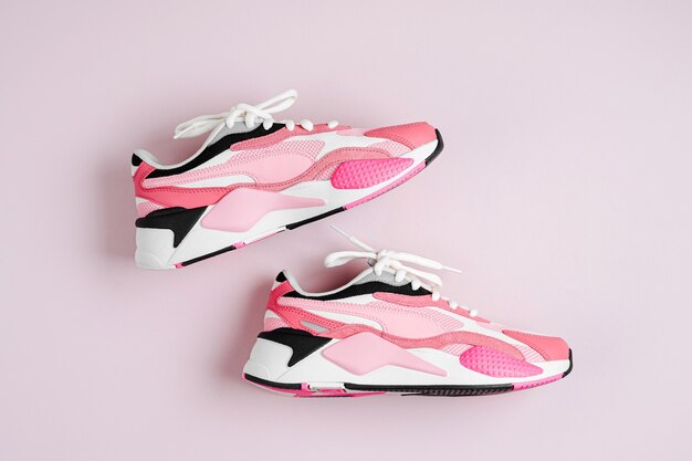 Tênis da moda feminina em um fundo rosa. Sapatos esportivos femininos. Conceito de fitness