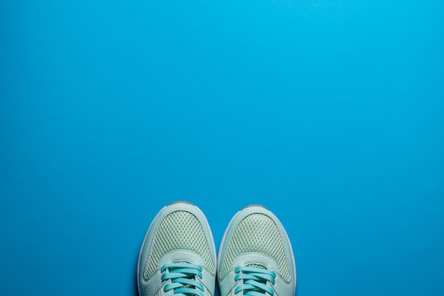 Foto tênis de bordeaux com sola branca em um plano de fundo azul