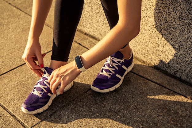 Tênis de corrida. closeup de tênis de corrida descalço. atleta amarrando cadarços para correr na estrada em tênis minimalistas com os pés descalços. corredor se preparando para o treinamento. estilo de vida do esporte.