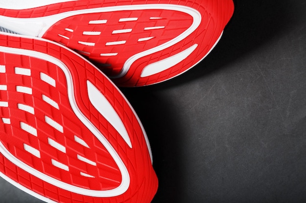 Tênis de corrida com sola vermelha em um fundo preto Closeup vista superior