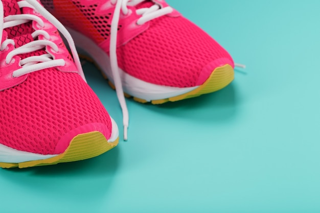 Tênis esportivos rosa para correr em um azul com espaço livre