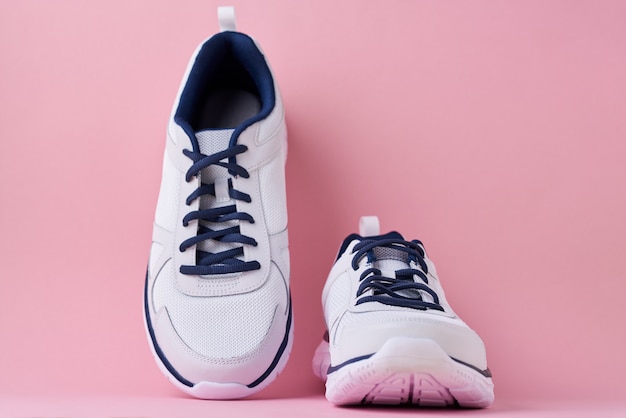 Tênis masculinos para correr em um fundo rosa