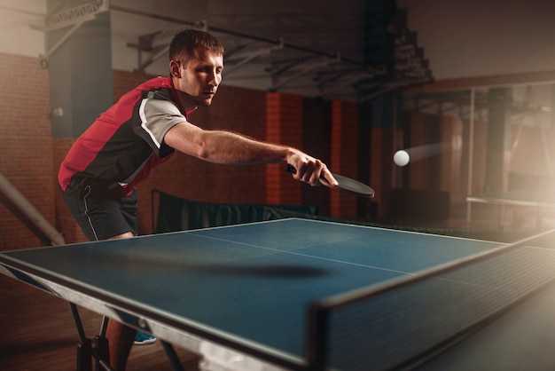 Tenis de mesa, hombre jugando, pelota con rastro. Entrenamiento de ping pong indoor