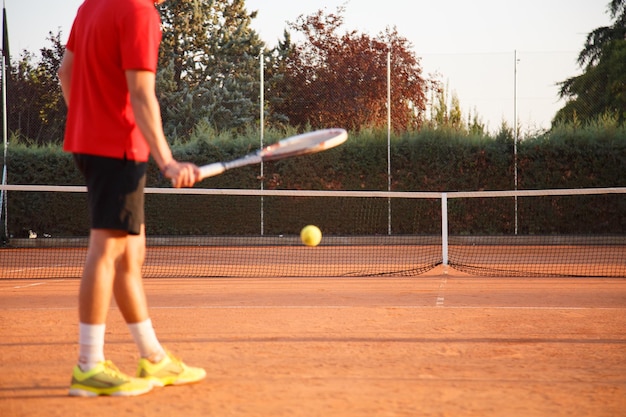 Tenista profesional anónimo botando la pelota