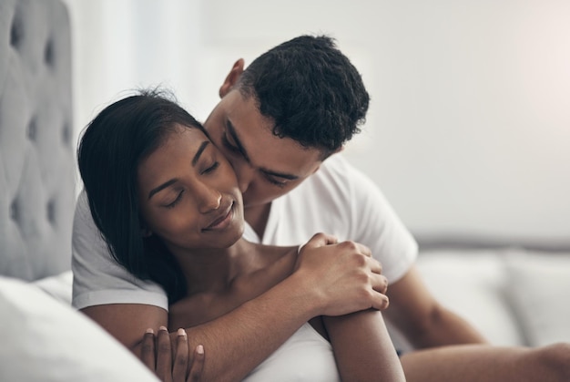 Tenme en tus brazos para siempre Fotografía de una pareja joven compartiendo un momento íntimo en casa