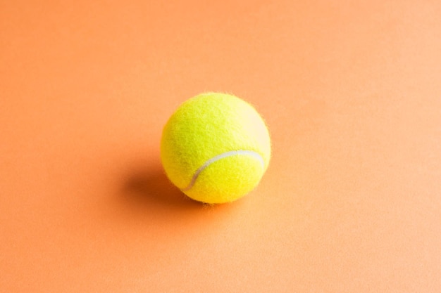 Tennisball auf orange abstraktem Hintergrund