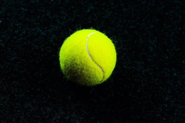 Tennisball isoliert auf Schwarz mit dramatischer Beleuchtung