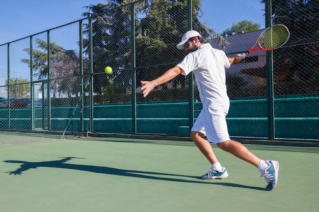 Tennisprofi, der auf Tennisplatz spielt.