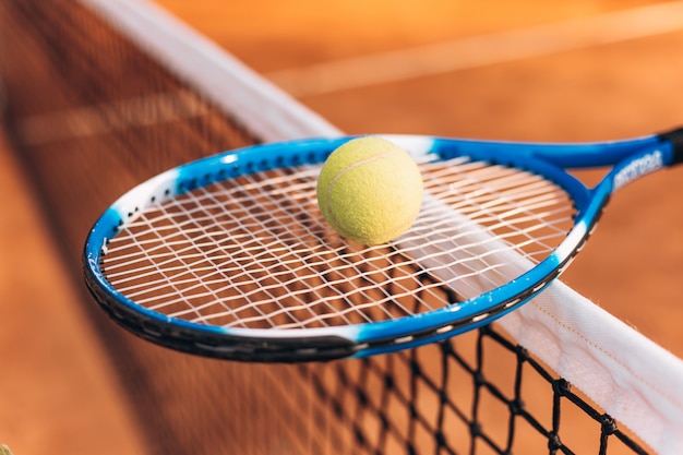 Foto tennisschläger mit einem ball auf dem tennisnetz