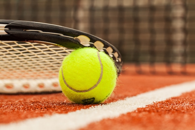 Tennisspiel. Tennisball und Schläger auf Platzhintergrund