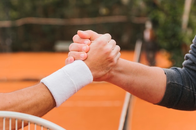 Tennisspieler, die Hände halten