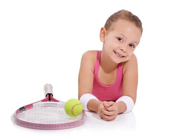 Tennissport und Porträt eines glücklichen Mädchens auf weißem Hintergrund für Training, Training oder Bewegung Fitness Lächeln und isoliertes junges Mädchen mit Schläger für Hobbyaktivität oder Spaß für Wellness im Studio