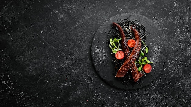 Tentáculos de pulpo horneados en salsa de ajo y pasta negra con tinta de sepia Comida de restaurante de lujo Mariscos Estilo rústico Flat Lay