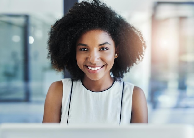 Tentando atingir seus objetivos através de negócios Foto recortada de uma jovem empresária atraente em seu escritório