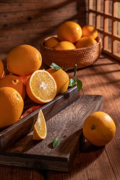 Bajo la tenue luz, las naranjas del plato están sobre la mesa de madera, como pinturas al óleo.