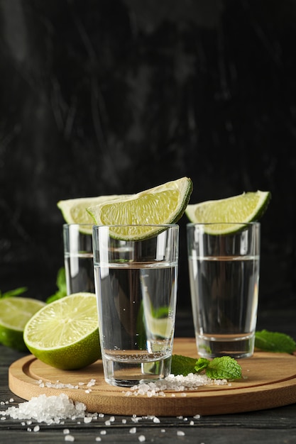 Tequila-aufnahmen mit limettenscheiben, salz und minze auf holz