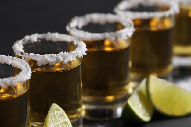 Tequila mexicana tira fatias de limão e sal em close de mesa cinzenta