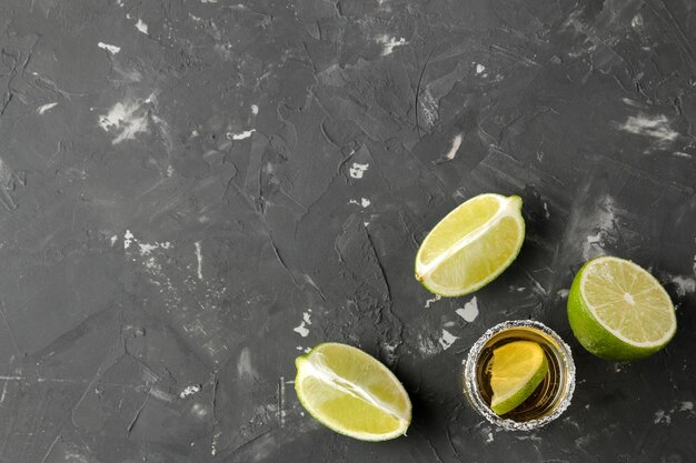 Tequila ouro em um copo de vidro com sal e limão em uma barra de fundo de concreto preto vista superior de bebidas alcoólicas com espaço para texto