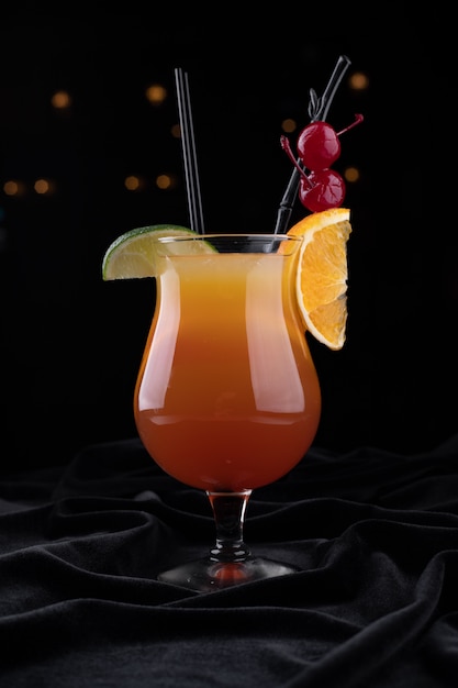 Tequila Sunrise cocktail, sobre una superficie negra