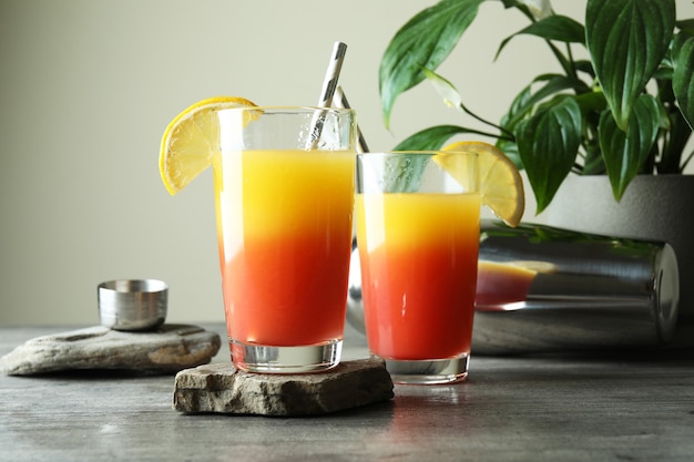 Tequila Sunrise Cocktails auf grau strukturiertem Tisch