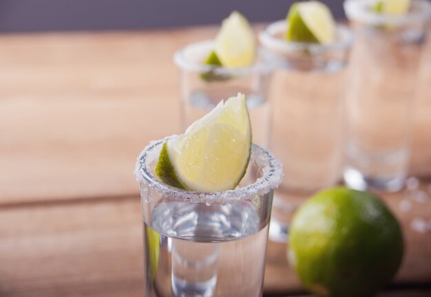 Tequila tiro com limão e sal do mar na mesa de madeira velha, foco seletivo