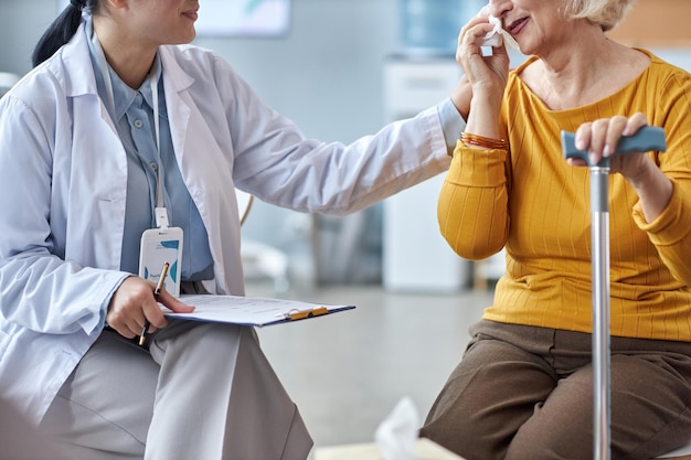 Terapeuta ayudando a una anciana llorando en una sesión de salud mental