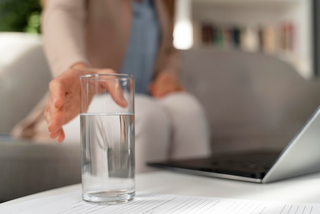 Foto terapeuta de close-up pegando um copo d'água