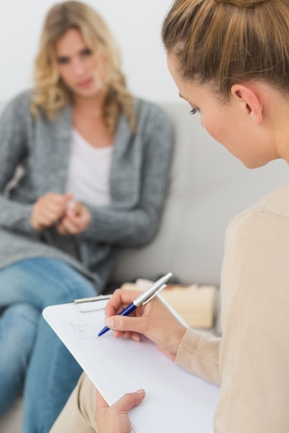 Terapeuta escribiendo notas en su portapapeles