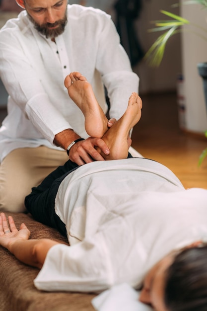 Foto terapeuta esticando as pernas da mulher massagem shiatsu