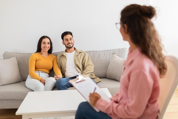 Terapeuta hablando con una pareja atenta durante la sesión