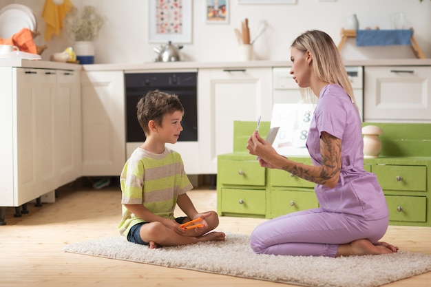 El terapeuta juega un juego educativo con el niño usando tarjetas lógicas.