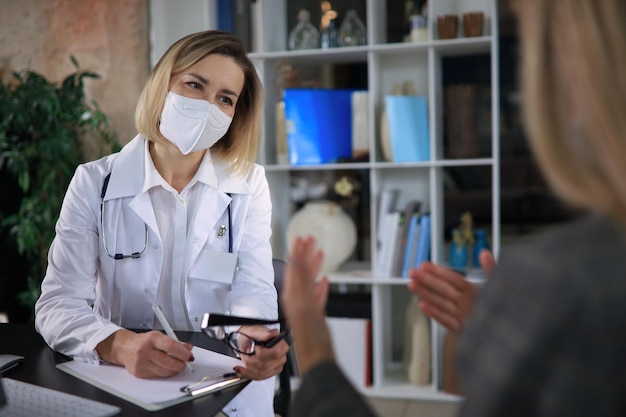 Terapeuta médica de meia idade em consulta com o paciente no escritório